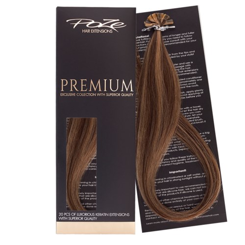 Hair extension sample attached to black card, showing shiny, light brown, straight hair on a tray.