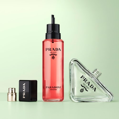En uppsättning Prada-parfymflaskor inkluderar en hög rosa spray, svart lock och en klar triangulär flaska.