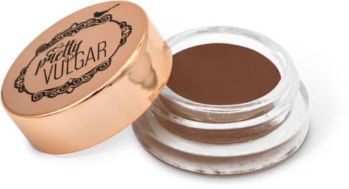 En liten burk med brun kosmetisk bal som har en guldfärgad lock med svart dekorativ design, märkt "Pretty Vulgar."