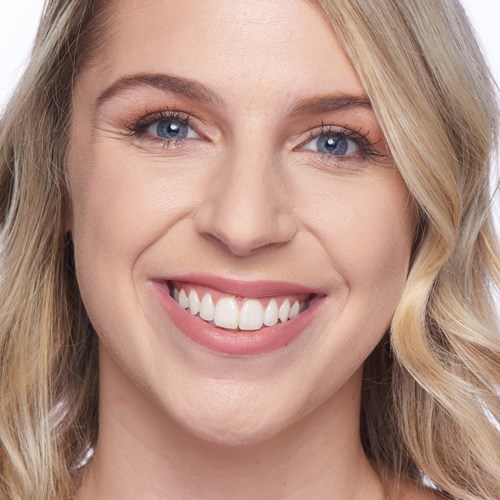 Bright smiling woman with blonde hair and blue eyes, clear skin, looking happy.