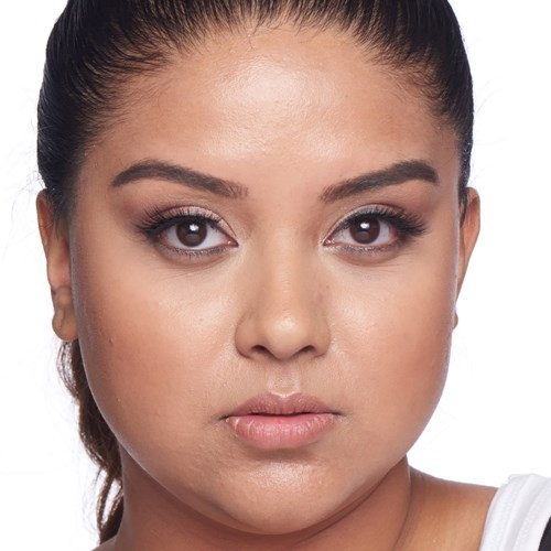 Close-up of a woman with dark hair, clear skin, and brown eyes, looking directly at the camera.