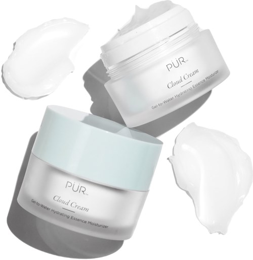 Två flaskor av PUR Cloud Cream-kräm med klickar av kräm runt dem på en vit bakgrund.