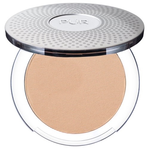 Et kompakt makeupprodukt med et beige presset pulver i en rund gjennomsiktig beholder, dekket med lokk i sølv.