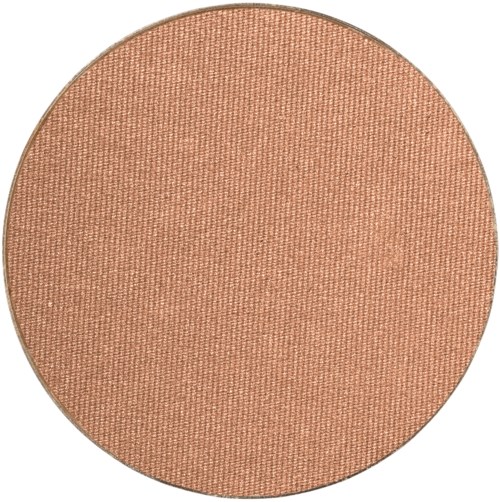 En rund makeupp blush med peachfärgad ton och en slät, strukturert yta.