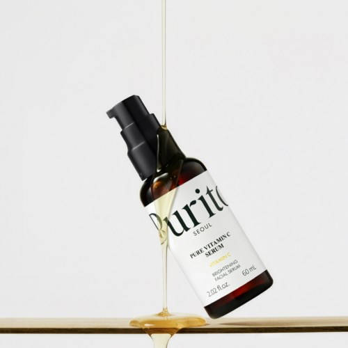 En brun flaska märkt Purito med serum som hälls ut och lutar ojämnt, spillandes på en yta.