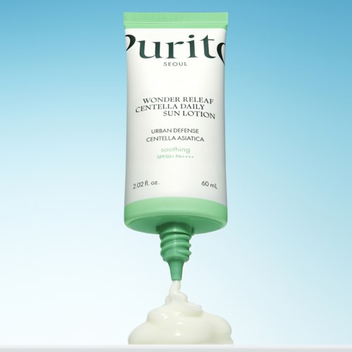 Een tube lotion met groene dop en label, die crème op een lichte achtergrond uitdrukt.