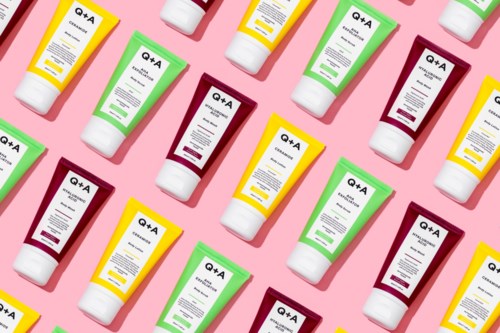 Multiple tubes of skincare products arranged diagonally on a pink background with colorful caps.