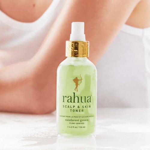 A light green bottle of Rahua scalp and skin toner with a gold cap and spray nozzle.