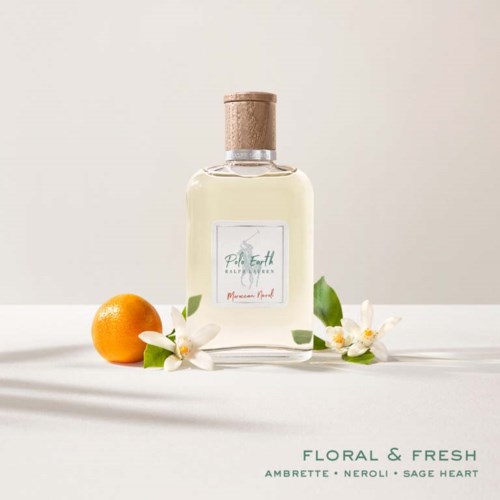 A bottle of perfume surrounded by an orange and white flowers on a white background.