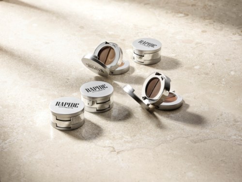 Several round containers with mirrors and the word RAPID on top are scattered on a light surface.