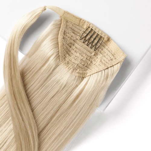 En blond hårförlängning med tygöverkant och clips för fästning.