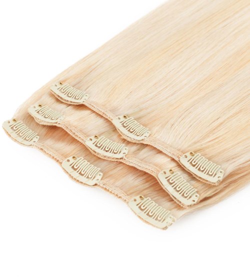 Flera självhäftande behåkupor ligger på ett beige tyg, används för stöd i kläder. De är kurvade.