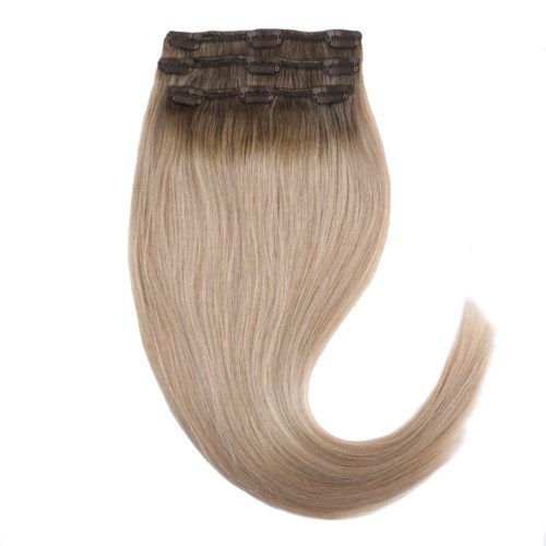 Clip-in hair extensions in blonde with dark roots, styled in a curled, glossy way.