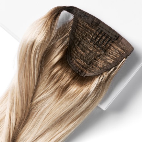 En blond hårförlängning med en tygklämma och små metallklipps för att fästa i naturligt hår.