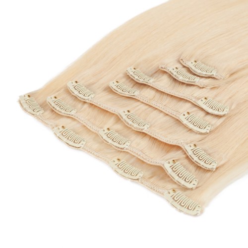 En hög av beige tygblöjor med justerbara knappar på en vit bakgrund.