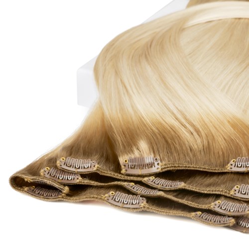 En blond peruk med lacefront är utlagd, visar dess struktur och färg.