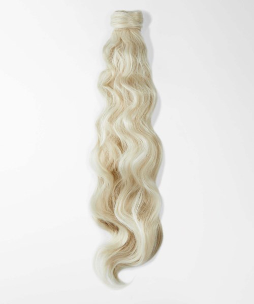 Blonder welliger Haarverlängerung oder Perücke hängt vor einem weißen Hintergrund.