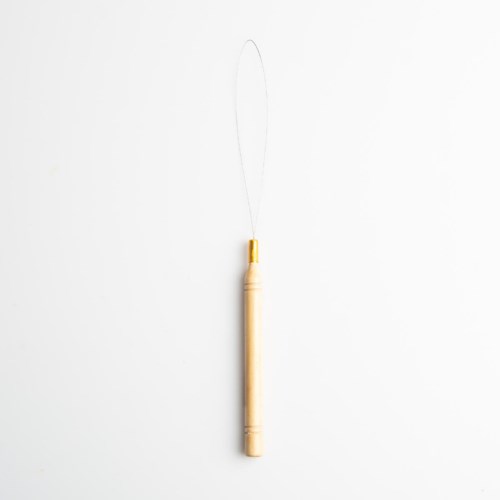 Een houten tandenborstel met lus hangt tegen een witte achtergrond.