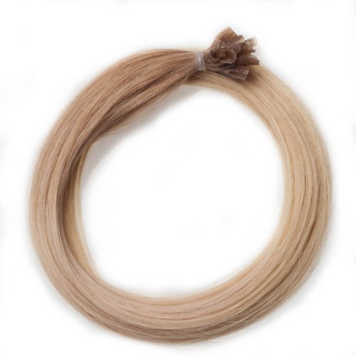 Blont hårklämmma knuten i en liten hästsvans, bildar en cirkel, på en vit bakgrund.