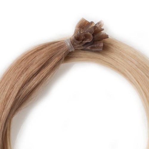 En blond hårförlängning knuten med ett litet, transparent plastband.