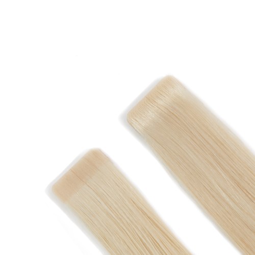 Två beige sminkborstar med långa mjuka borst är placerade diagonalt på en vit bakgrund.