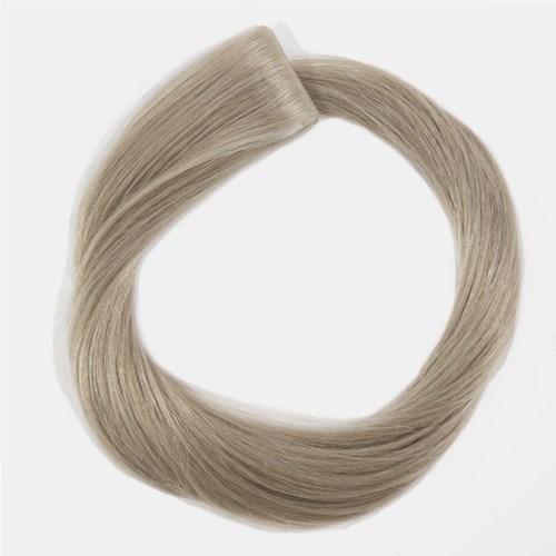 A hair extension secured with a clip, light blonde color, smooth and shiny texture, forming a loop shape.