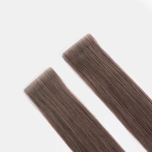 Two hair extensions or rollers in a brown shade, placed diagonally on a white background.