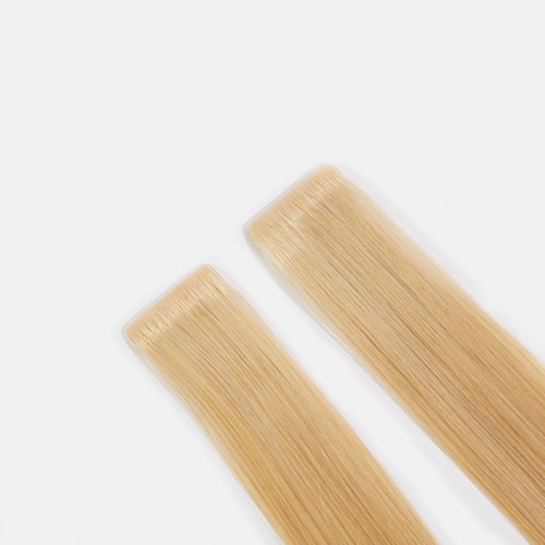 Two blonde hair extensions or strips placed on a white background.