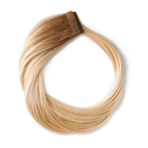 Blont hår är fastsatt vid en brun klämma, vilket bildar en loop med släta, glänsande strån.