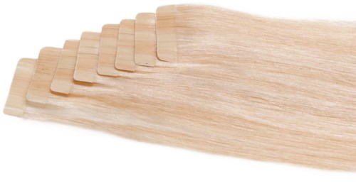 Multiple thin, blonde hairpieces or wig clips are aligned side by side, overlapping each other slightly.