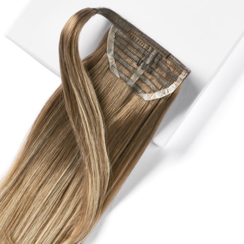 Hårförlängning med naturligt blont hår och clip-in-stil, placerad på en vit yta.