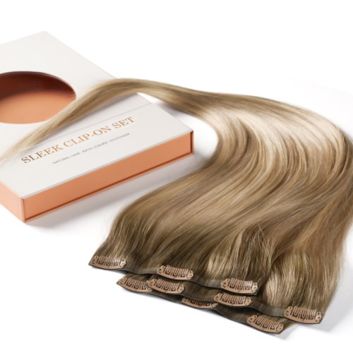 Laatikko, jossa lukee "SLEEK CLIP ON SET" ja hiuslisäkkeitä, jotka kiinnittyvät klipseihin.