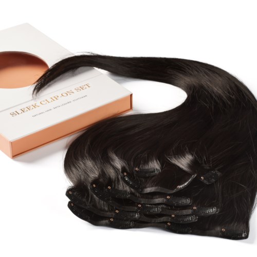 A set of hair extension rollers and dark hair extensions on a white background.