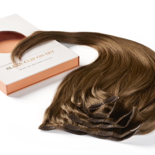 Hair extension set with brown clips, hair strands, and a box. The box is white with a pink edge.