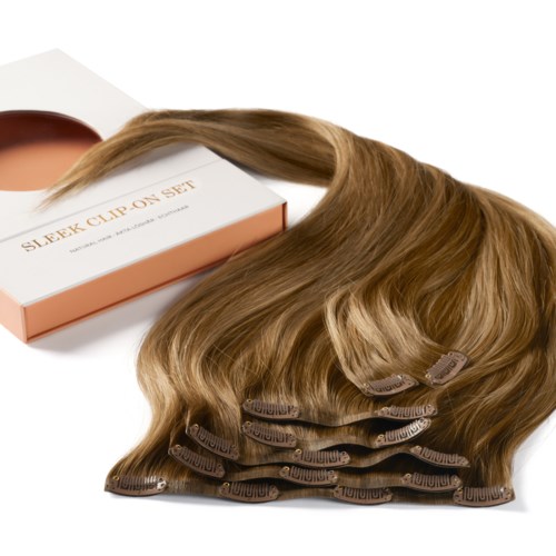 Een set haarclipjes met lange, golvende lichtbruine haarextensions en een doos met 'Sleek Clip On Set'.