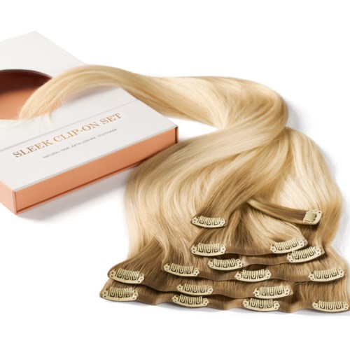 Blondas hårförlängningar med klipps, kopplade till en låda som är märkt "Sleek Clip On Set."
