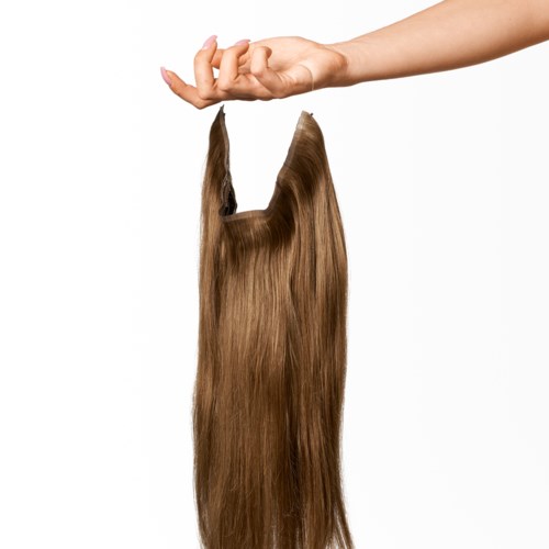 A hand holds a lock of long, brown hair.