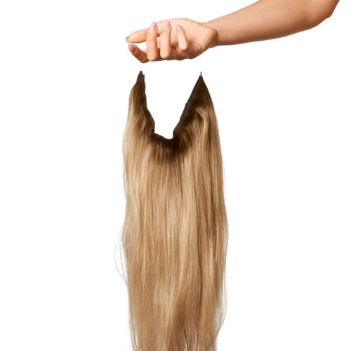 A hand is holding a clip of long, blonde hair in the air.