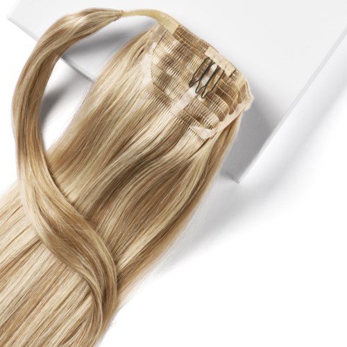 Een blond haarstuk met clips ligt op een witte ondergrond.