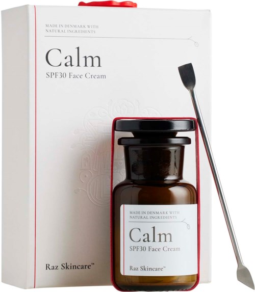 En hudvårdsuppsättning med en låda, en liten mörk flaska märkt 'Calm SPF30 Face Cream' och en metallapplikator.