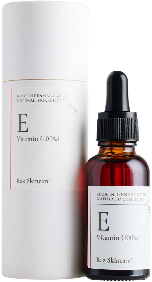 Kleine amberkleurige glazen fles met pipet, gelabeld E Vitamin, naast een lange witte container van Raz Skincare.