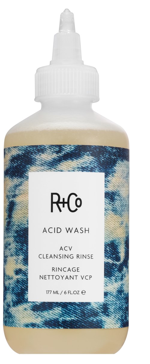 En flaska Rh+Co Acid Wash, med en blå och vit mönstrad etikett och droppkork.