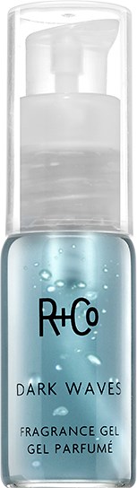 En liten, klar flaska med blå gel inuti, märkt R+Co Dark Waves doftgel, med pump.