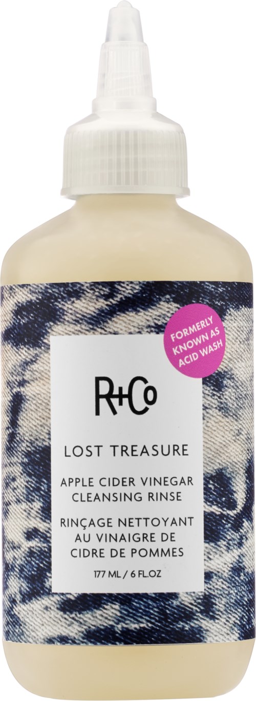 En beige flaska med vit spraykork, märkt "Lost Treasure" äppelsidvin vinäger sköljmedel.