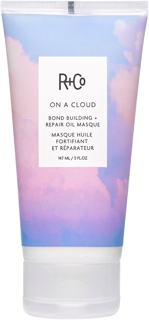 En hårinpackningsrör med himmel- och molnmotiv, märkt "R+Co On A Cloud" för att reparera och stärka håret.