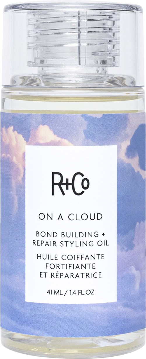 Eine klare Flasche mit Himmel Hintergrund und weißem Etikett, enthält Stylingöl für Haare.