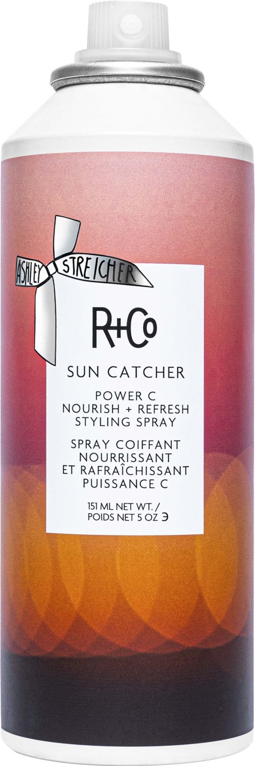 En solfångare styling sprayflaska med en rosa- och orangegradient etikett, svart lock och vit spraymunstycke.