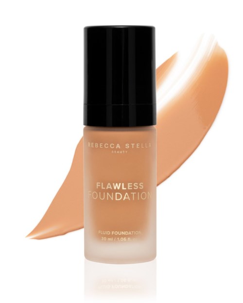 En flaska flytande foundation i beige färg med svart lock, bakom ett beige prov. Text på flaskan inkluderar varumärke och produktnamn.