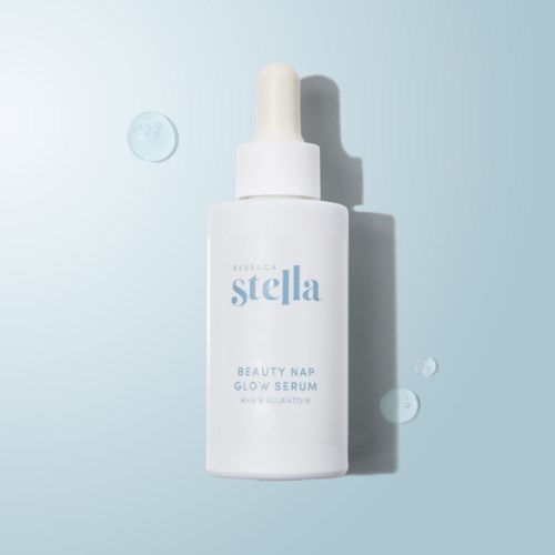 A white bottle with a dropper cap labeled 'Rebecca Stella Beauty Nap Glow Serum' on a light blue background.