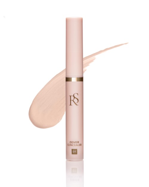 En rosa kosmetikkapsel med gullbånd, merket 'RS', og en beige krem bak.